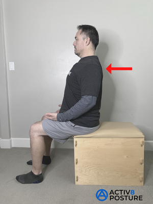 Woman seated on a chair squeezing her shoulder blades together